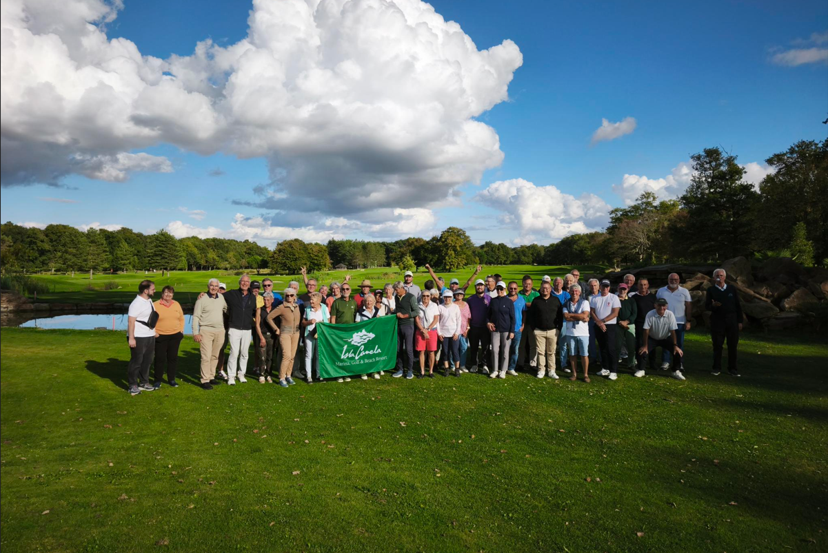 Los asistentes posan sobre el campo de golf de Poitiers Mignaloux con una bandera de Isla Canela
